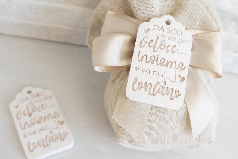 Regali e Bomboniere - Prodotti - SEGNAPOSTO  - SEGNAPOSTO 6,5X4CM CON FRASE DA SOLI SI VA PI VELOCE INSIEME SI VA PI LONTANO 